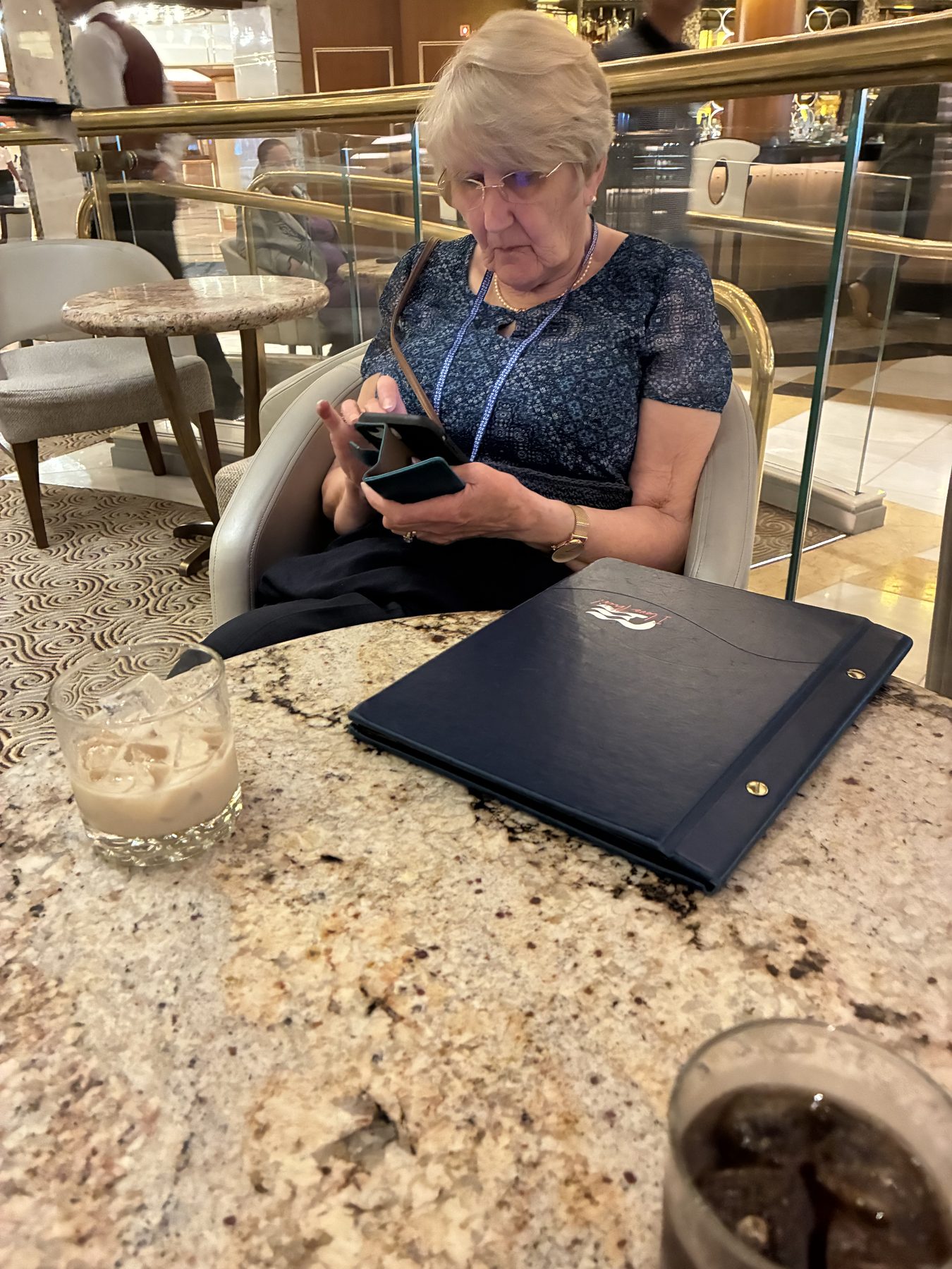 Frances reading the menu with a White Russian on the table