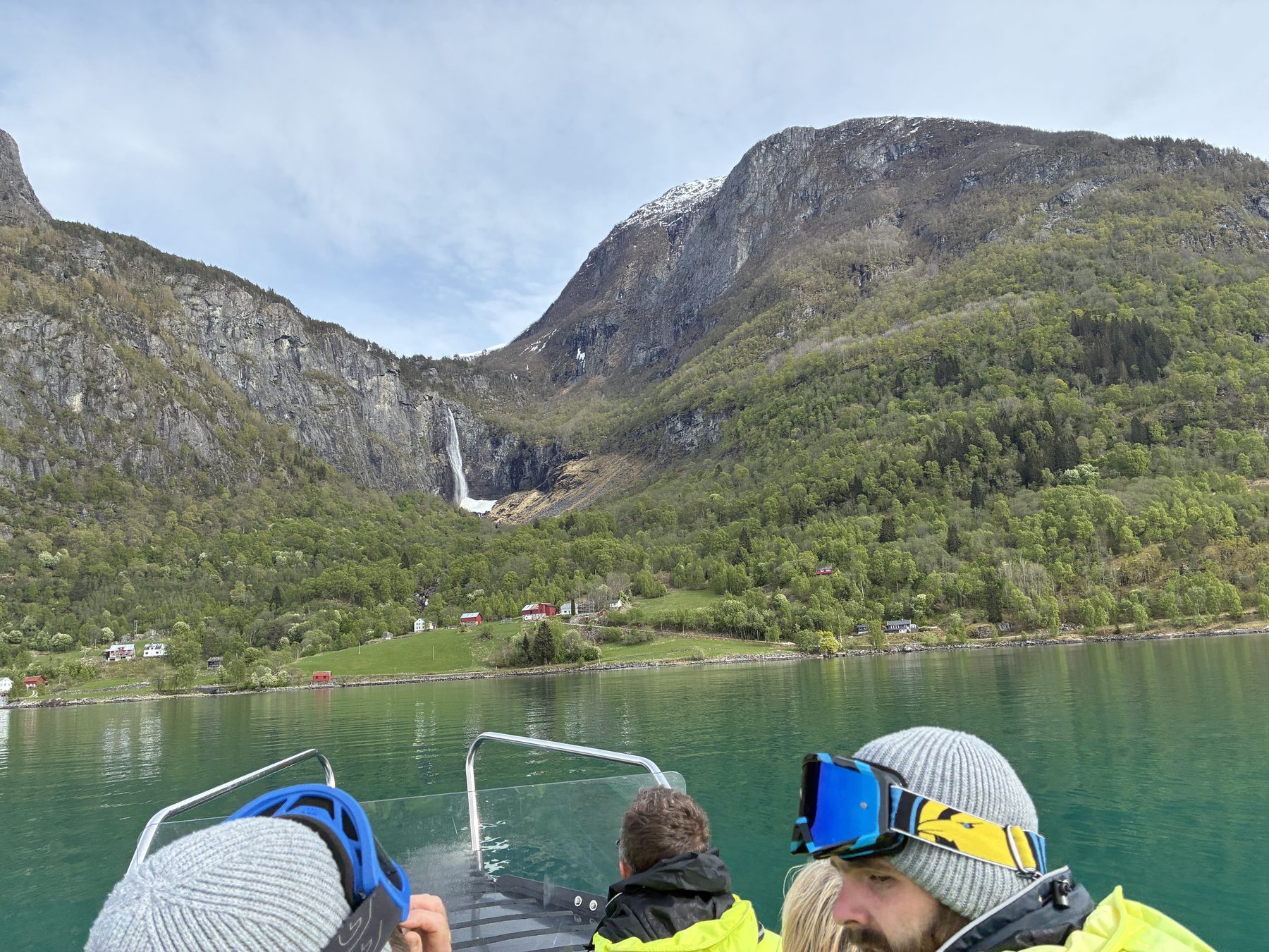 A wide quiet view of the fjord, mirror-still water with snow peaks in the distance