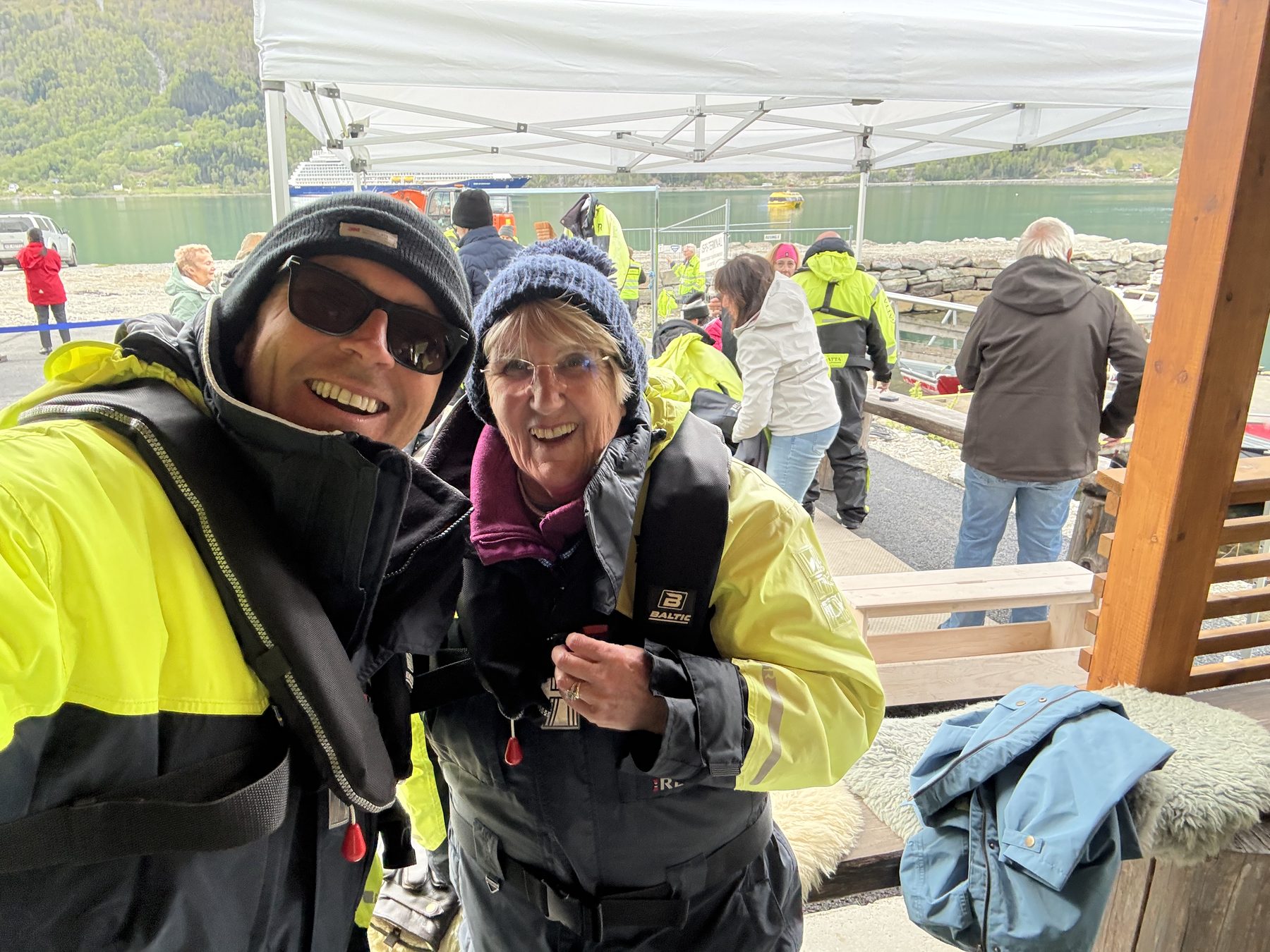 Stuart and Frances under the briefing tent, Sky Princess across the fjord behind
