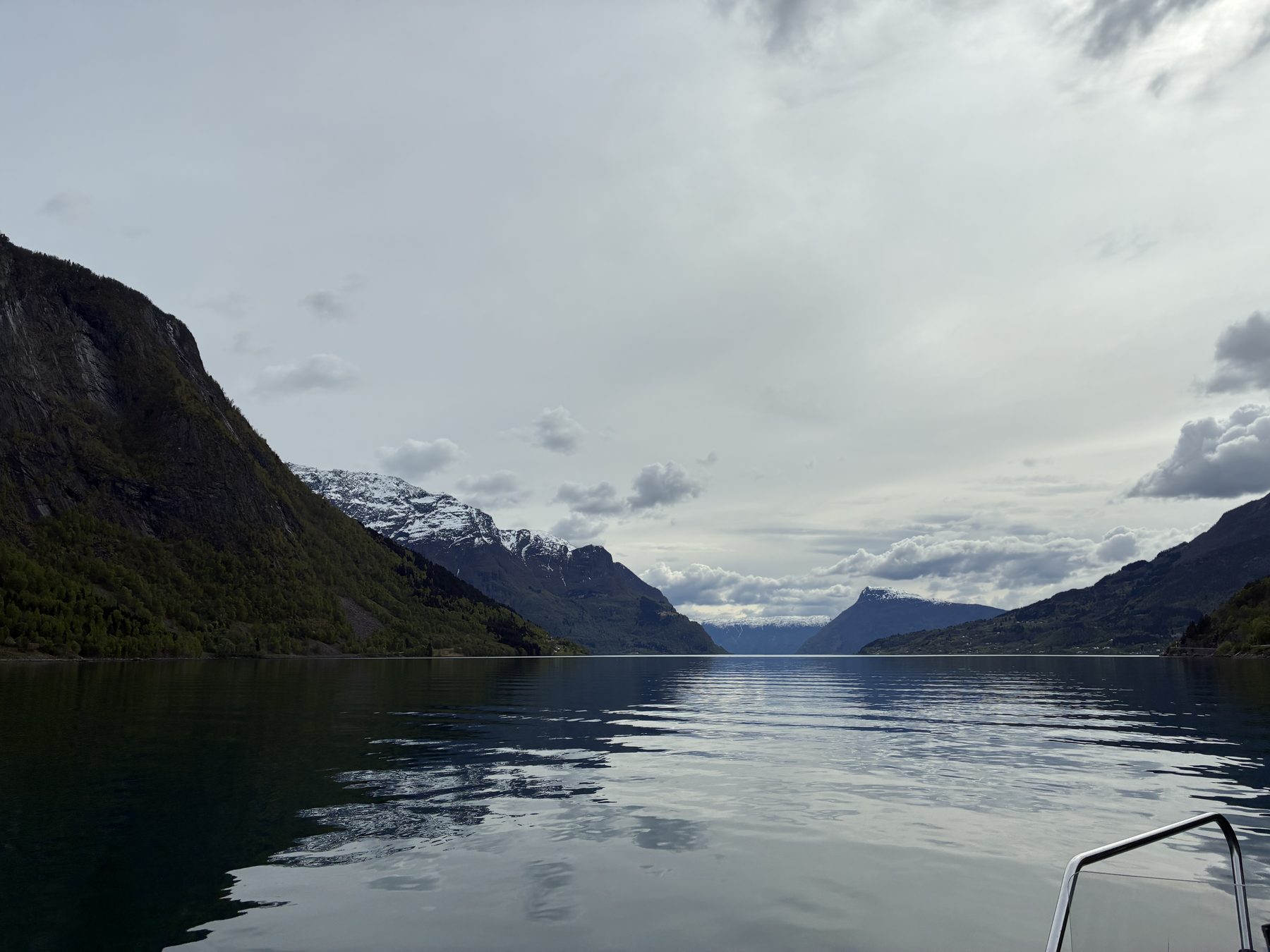 A huge waterfall cascading down the cliff into the fjord, viewed from the RIB